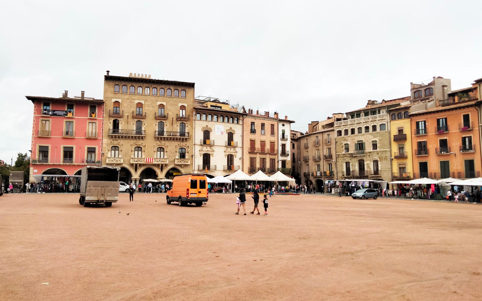 Broad sandy Plaça Major in Vic enclosed by arcaded historic façades